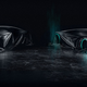 Two sports cars with glowing wheels under a large tarp.